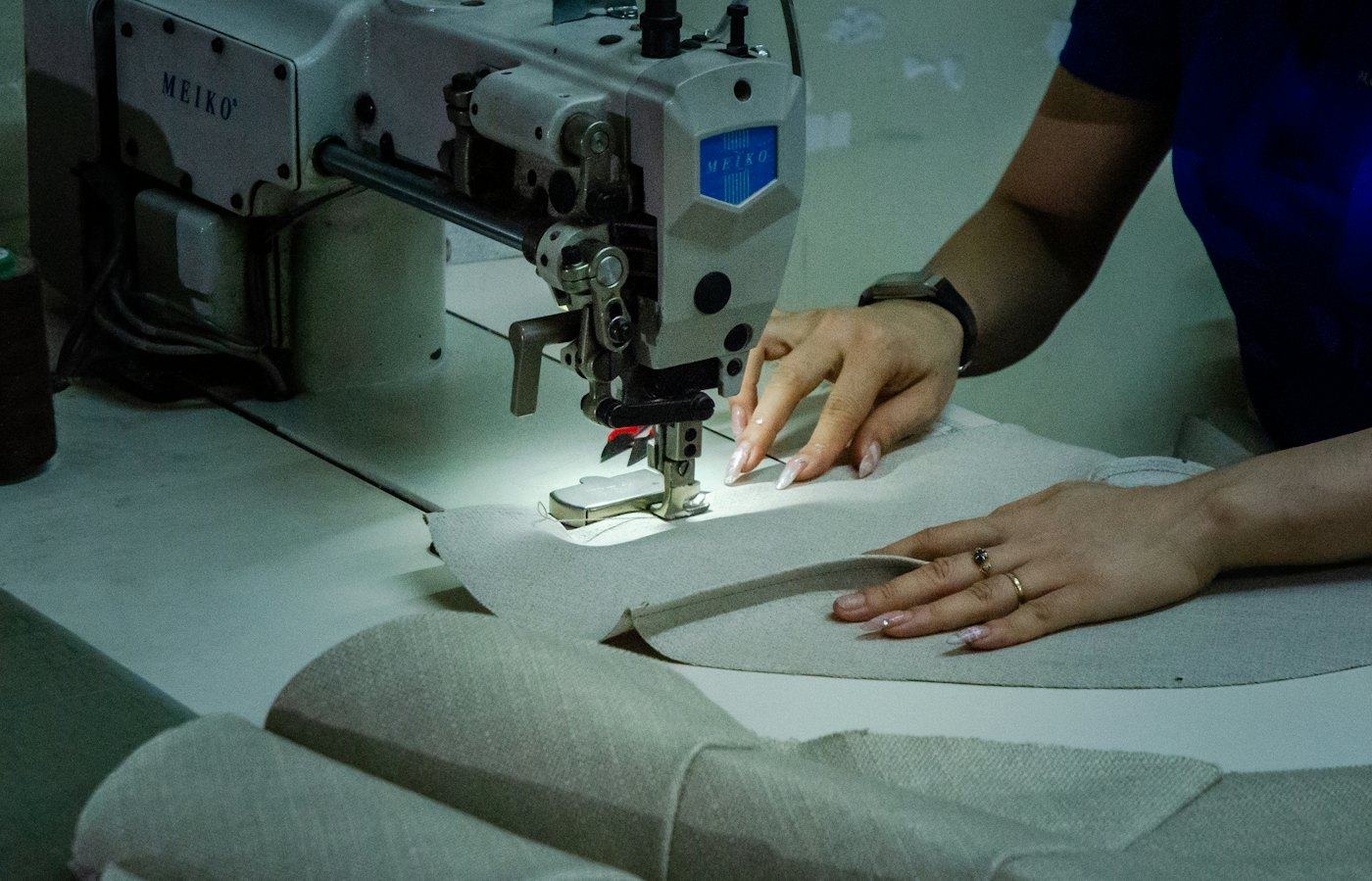 Costureira trabalhando em máquina de costura industrial